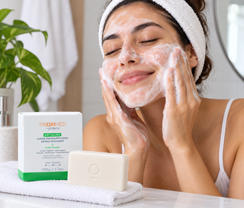 Mujer lavando su rostro con el Jabón Dermolimpiador Antiacné de Trioximed.
